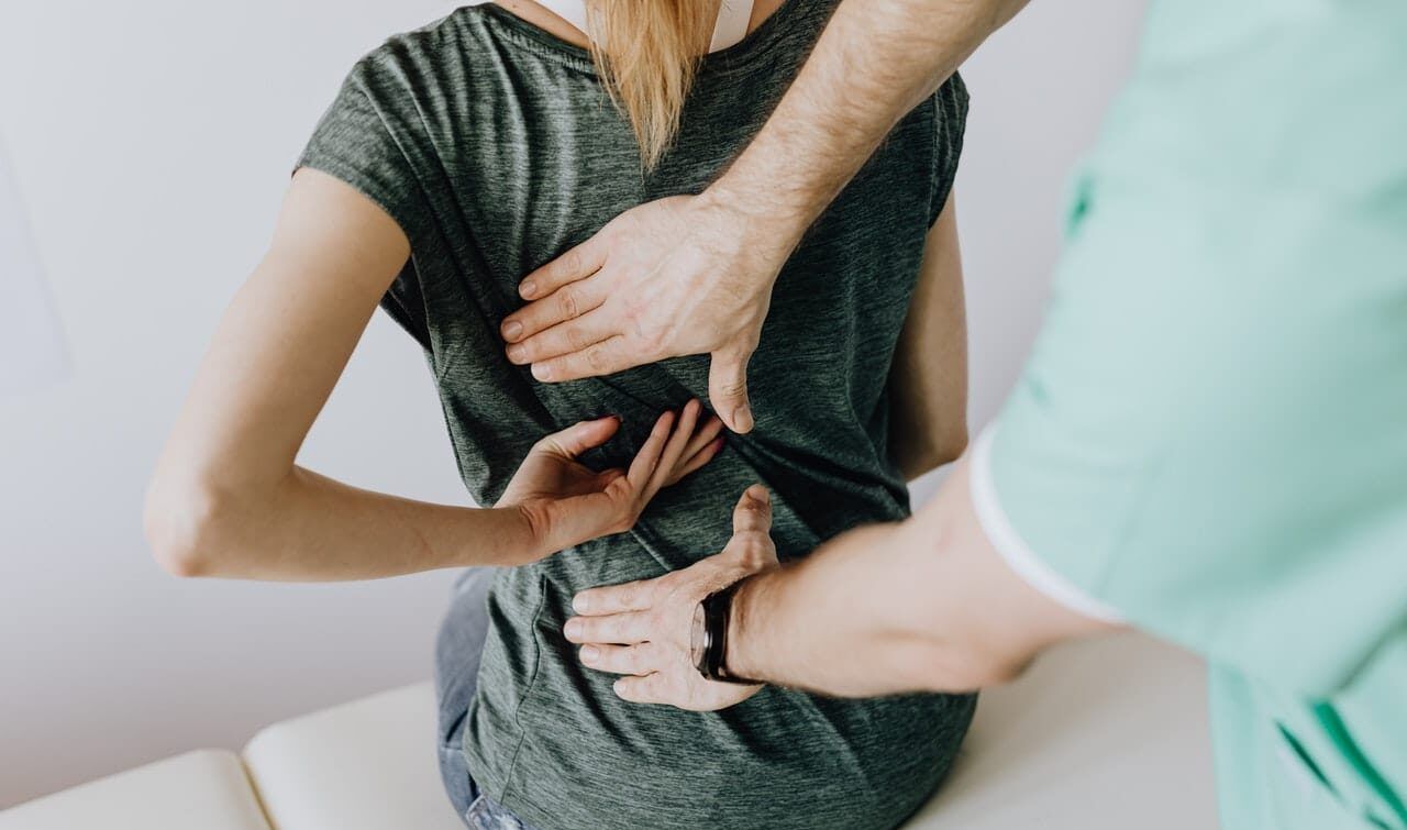 doctor putting hands on a woman's back