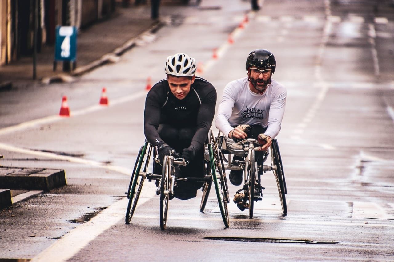 two men using handicap-able bicycles after work injuries.