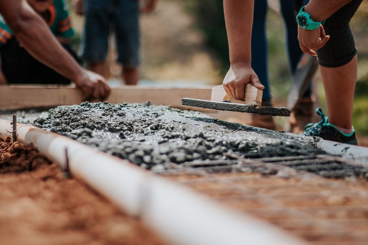 construction workers using tools to level cement