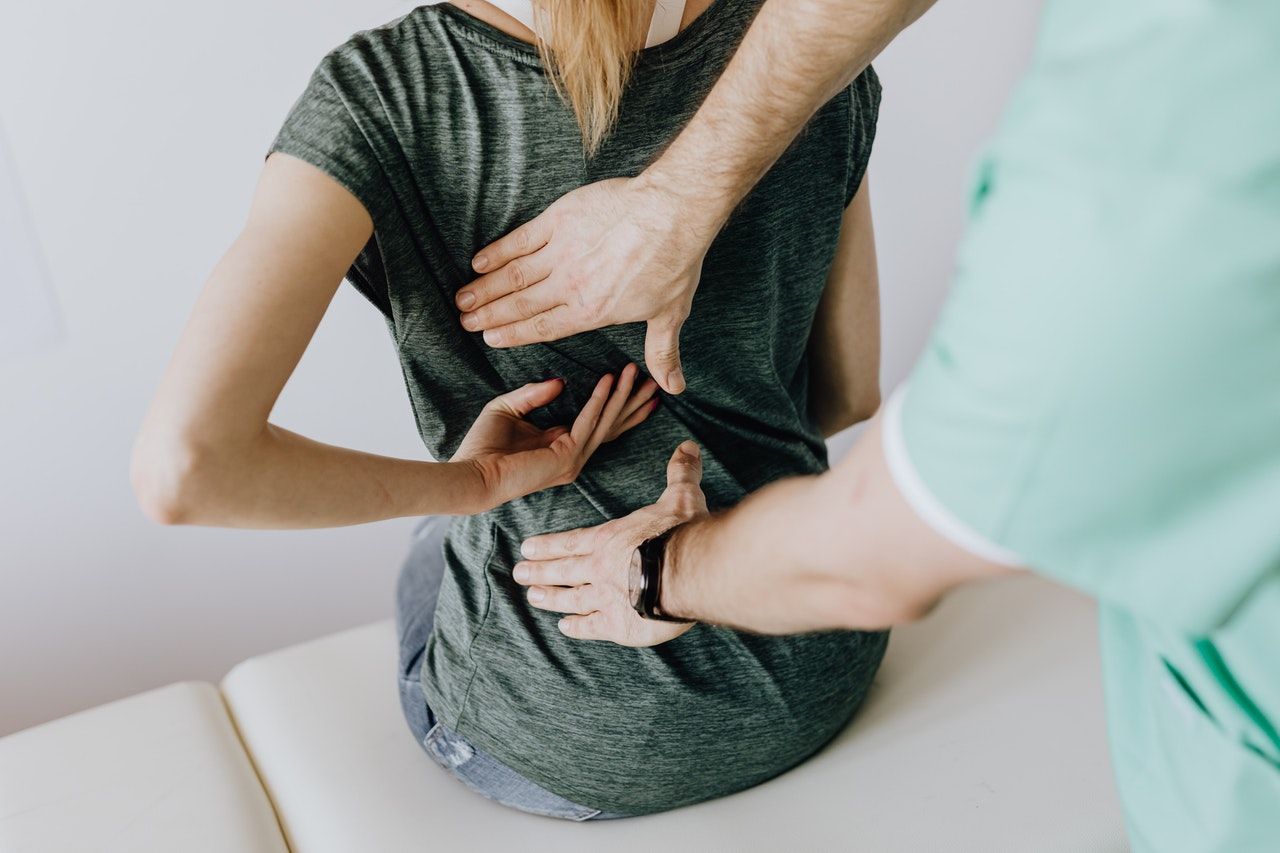 doctor putting hands on a woman's back