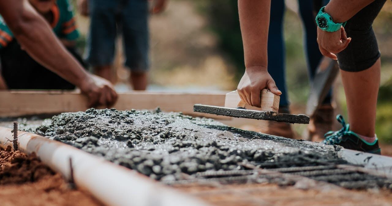 construction workers using tools to level cement